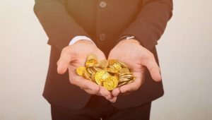homme tenant dans ses mains des pieces de bitcoin en or - bonuscasinogratuit.net